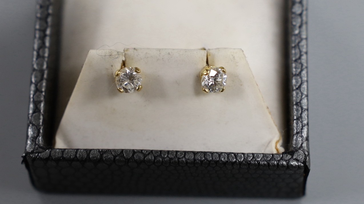 A pair of 18kt and solitaire diamond set ear studs, gross weight 1.2 grams.